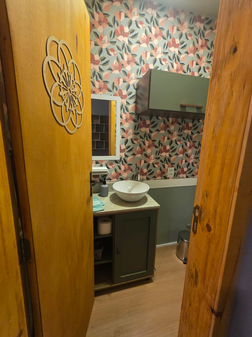 Sala 01 Alura — ambiente amplo com escada caracol, sofá verde e decoração oriental